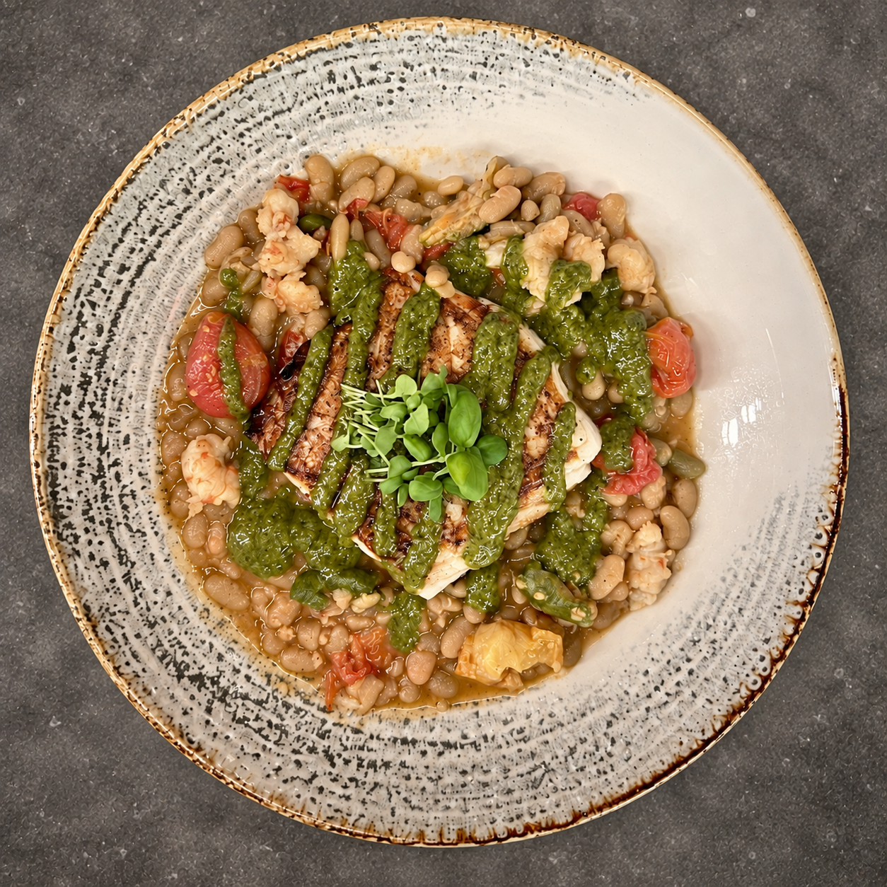 A plated private-chef meal with white beans, vegetables, and herb sauce